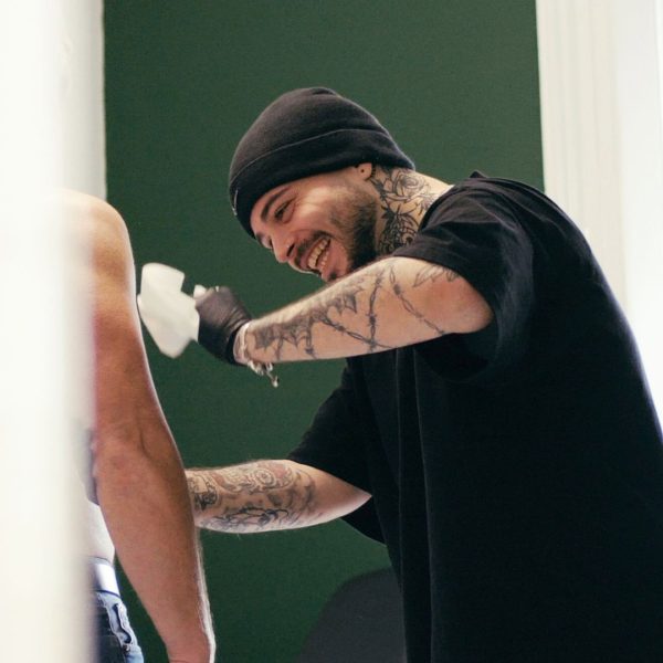 Resident artist Bugra Bizel putting a stencil on a clients arm at our Cardiff tattoo studio.