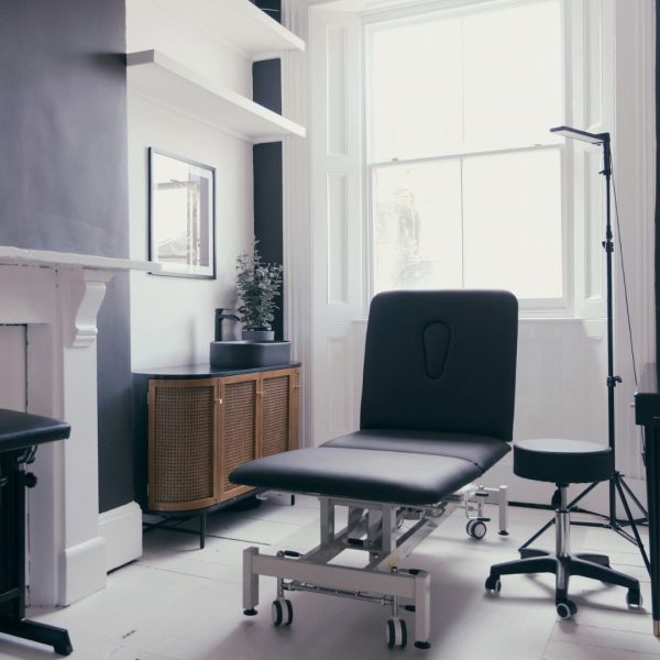 A private room at our Cardiff tattoo studio with large windows and a tattoo bed in the middle of the room