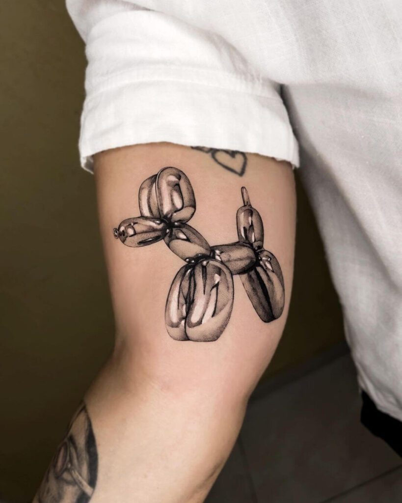 Tattoo on inner bicep of chrome balloon dog.