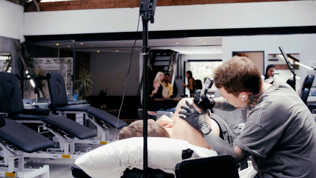 Male tattoo artist tattooing in an empty London tattoo studio.