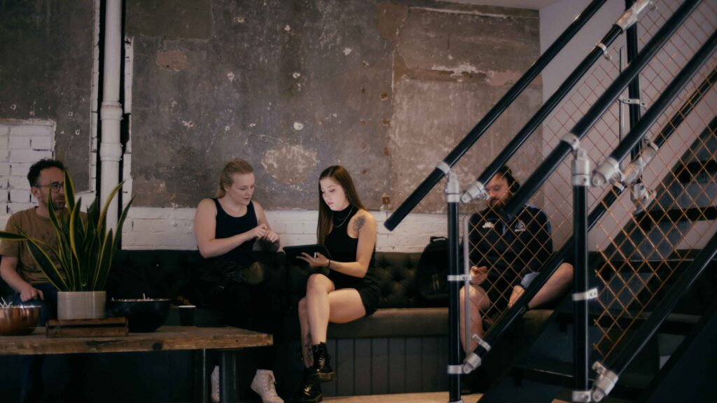 Tattoo and artist sitting on a sofa having a tattoo consultation.