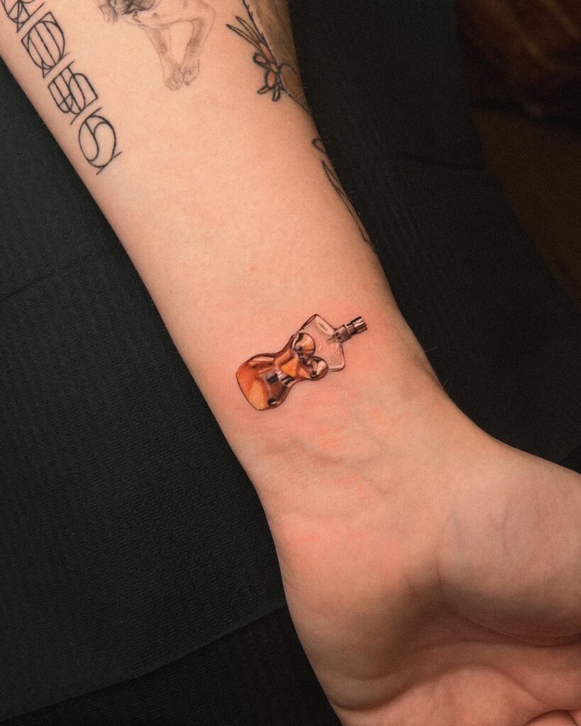 Micro realistic wrist tattoo of a Jean Paul Gaultier 'Classique' perfume bottle.