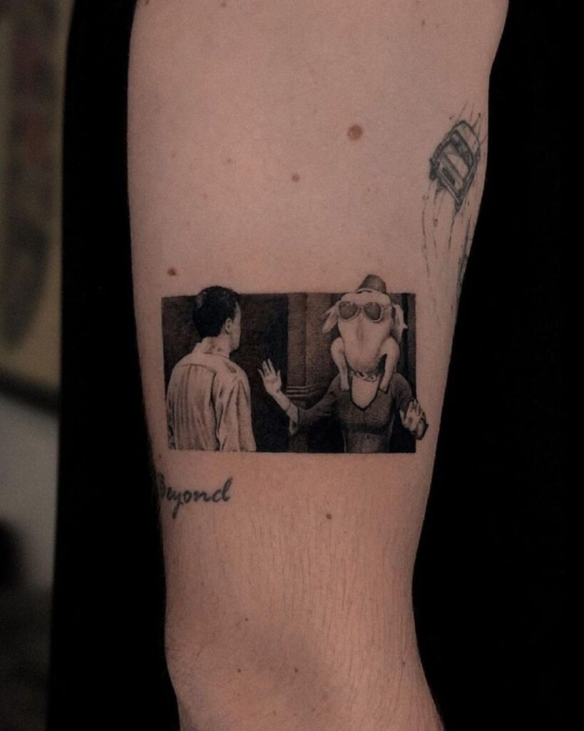 TV show tattoo: A micro realism black and grey tattoo of the famous Friends scene where Monica has a turkey on her head wearing glasses and a fez.