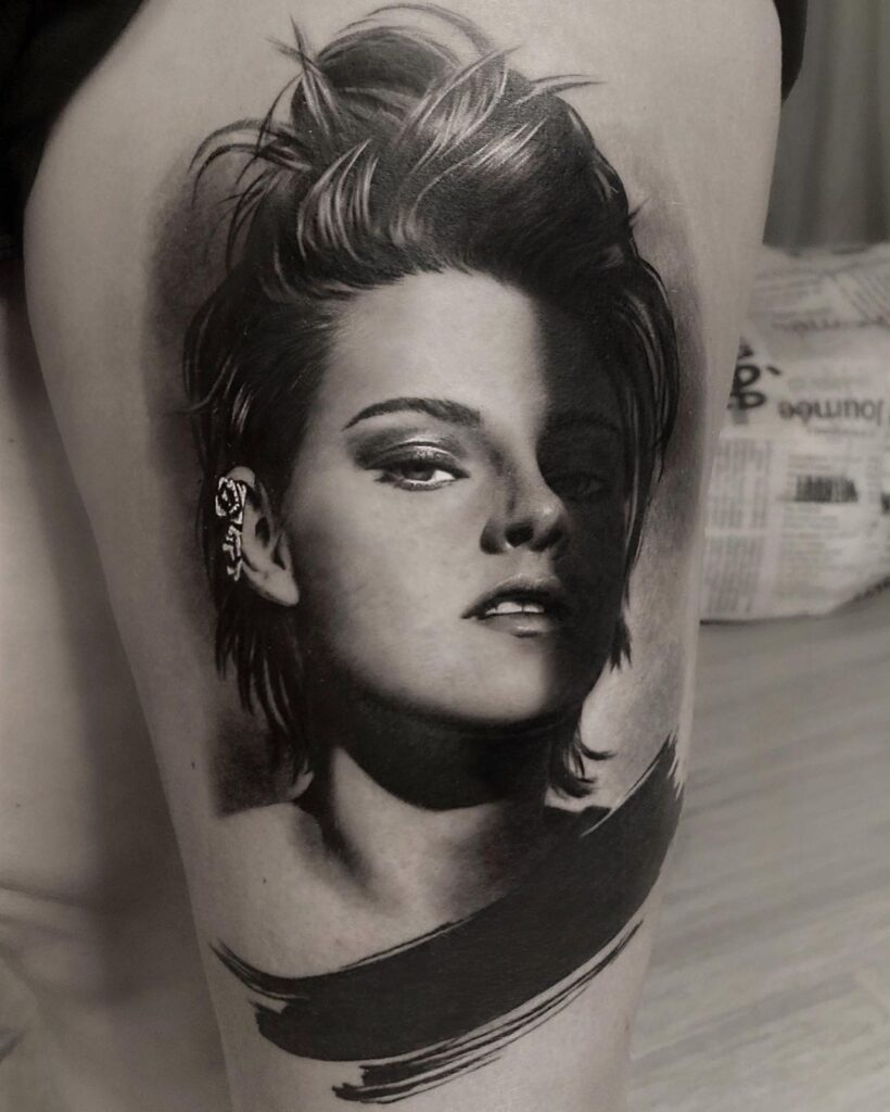 A black and grey portrait tattoo of Kristen Stewart. 